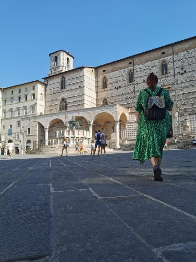 ragazza che cammina in una piazza a Perugia