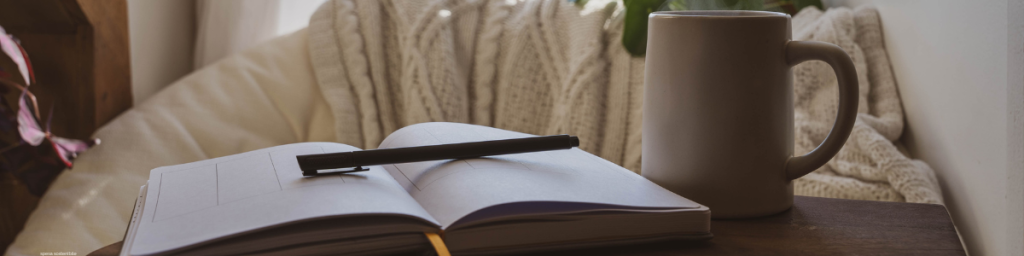 banner articolo fare journaling, immagine con journal penna e tazza