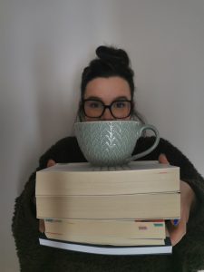 foto ragazza con pila di libri e tazza